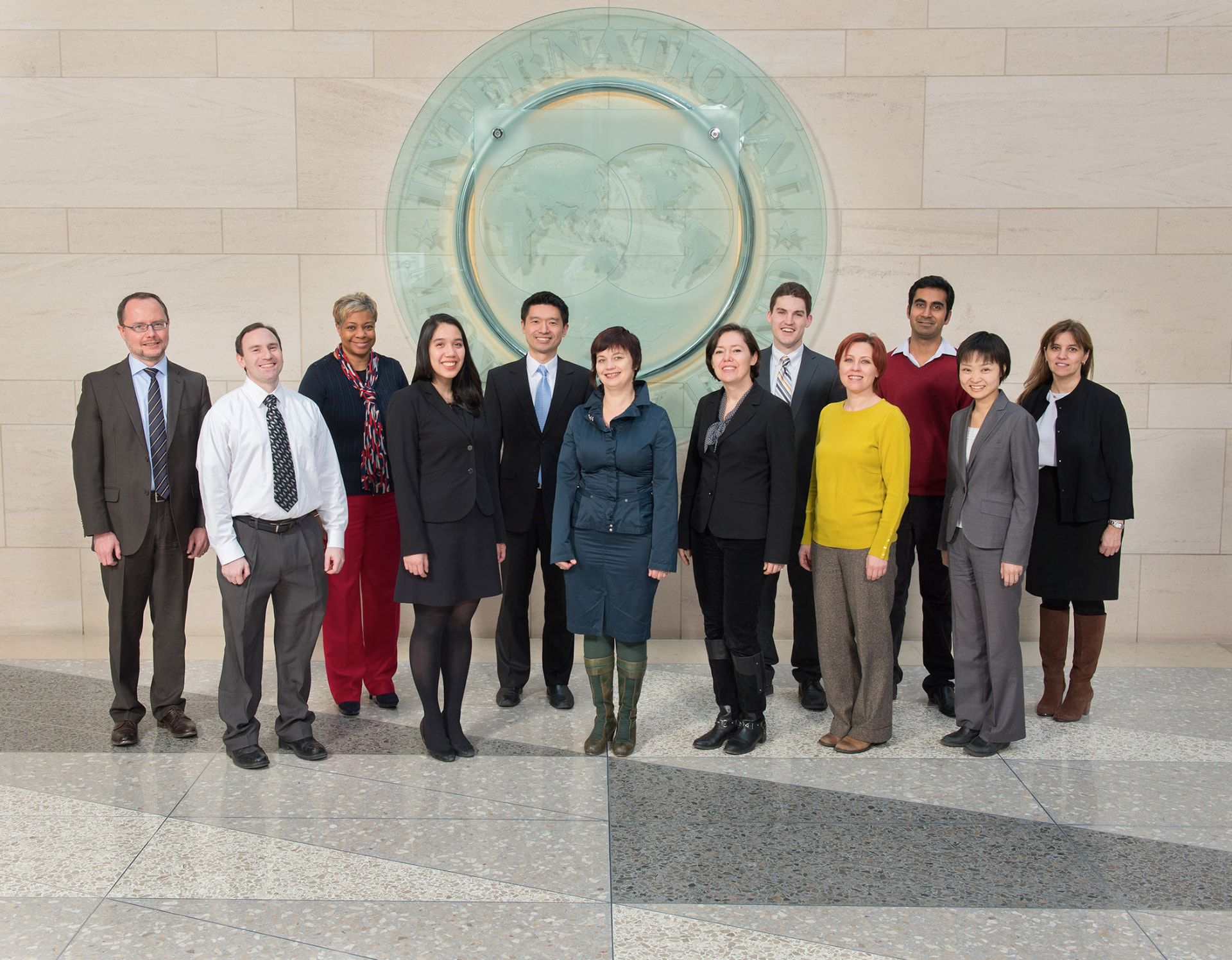 Patrick J. Healy with colleagues in front of the International Monetary Fund seal