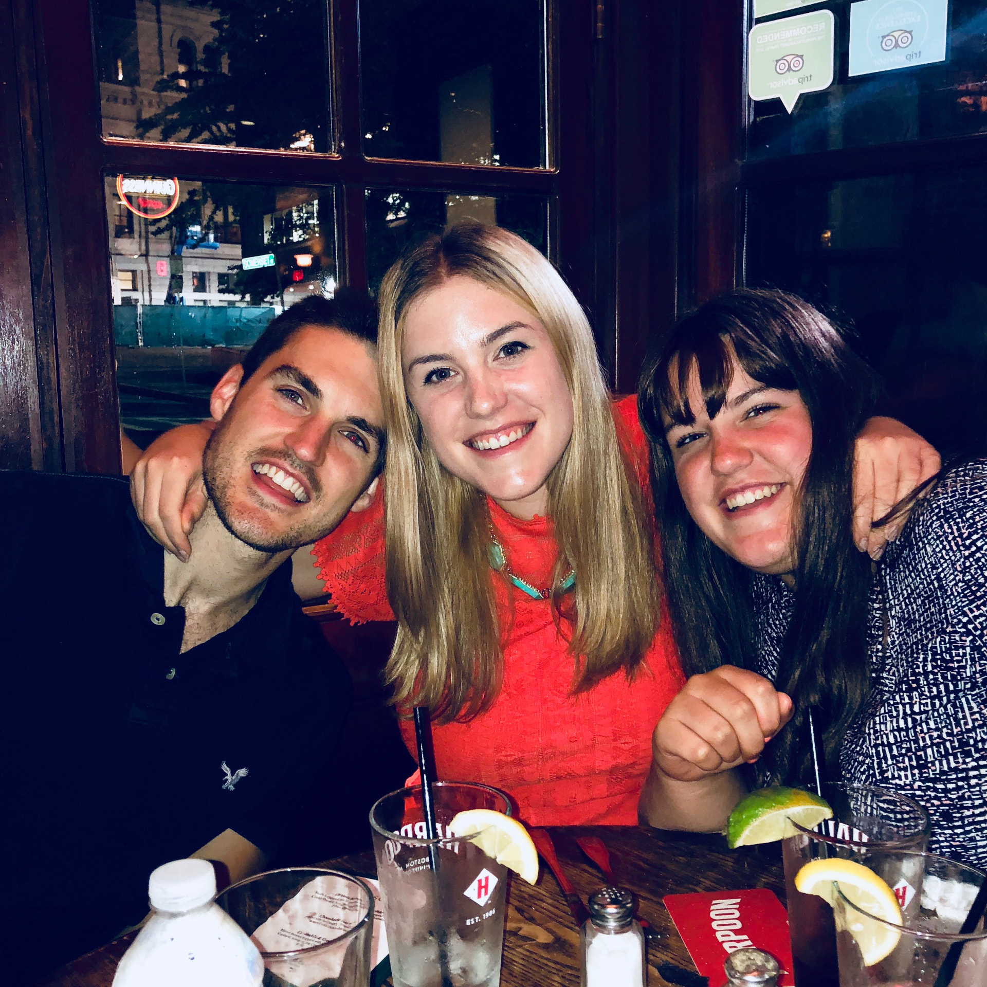 Patrick smiling with two companions during a night out