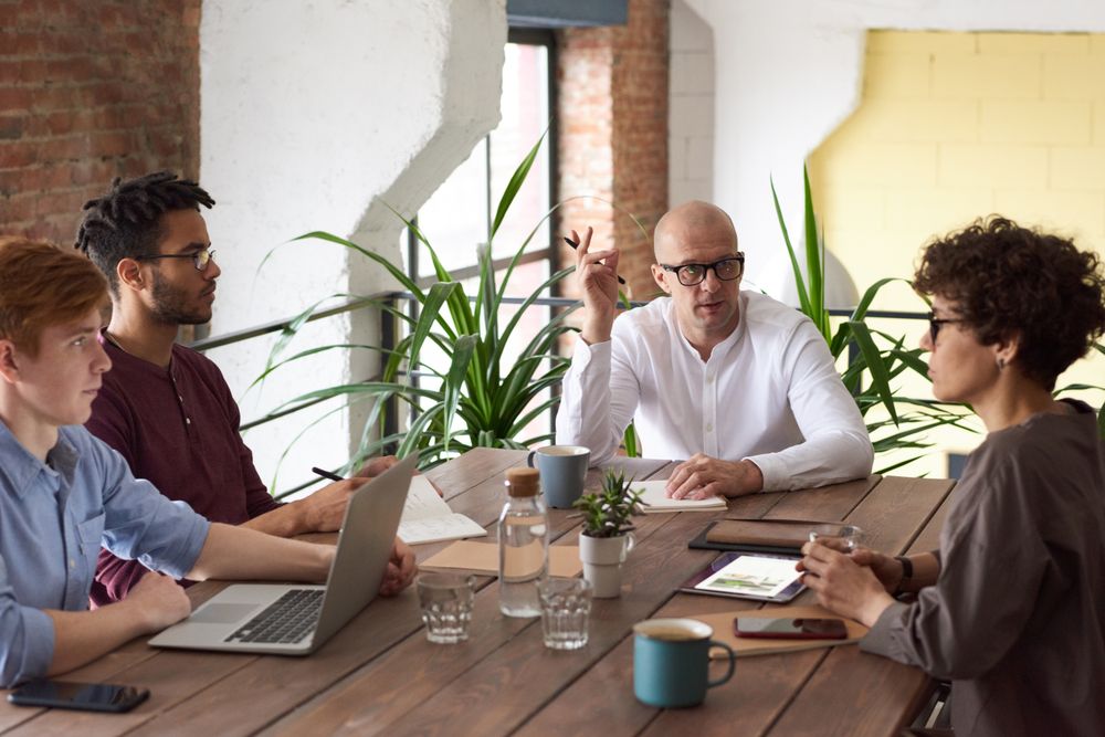 A leader meeting with team members around a table
